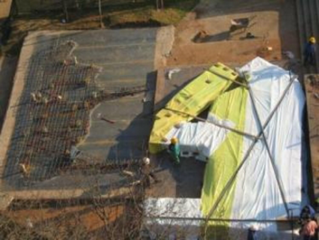 The concrete has been cast and is curing under plastic sheets