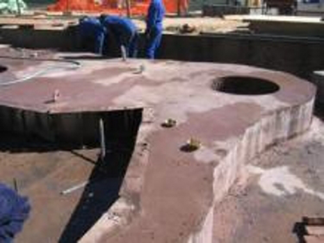 Cleaning the concrete before lifting the sculpture into place